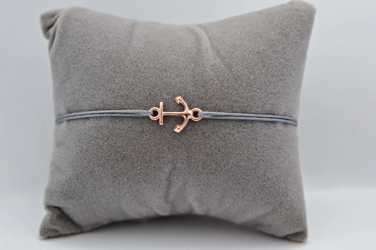 Roségoldenes Anker Armband mit grauem Bank auf einem grauen Schmuckkissen