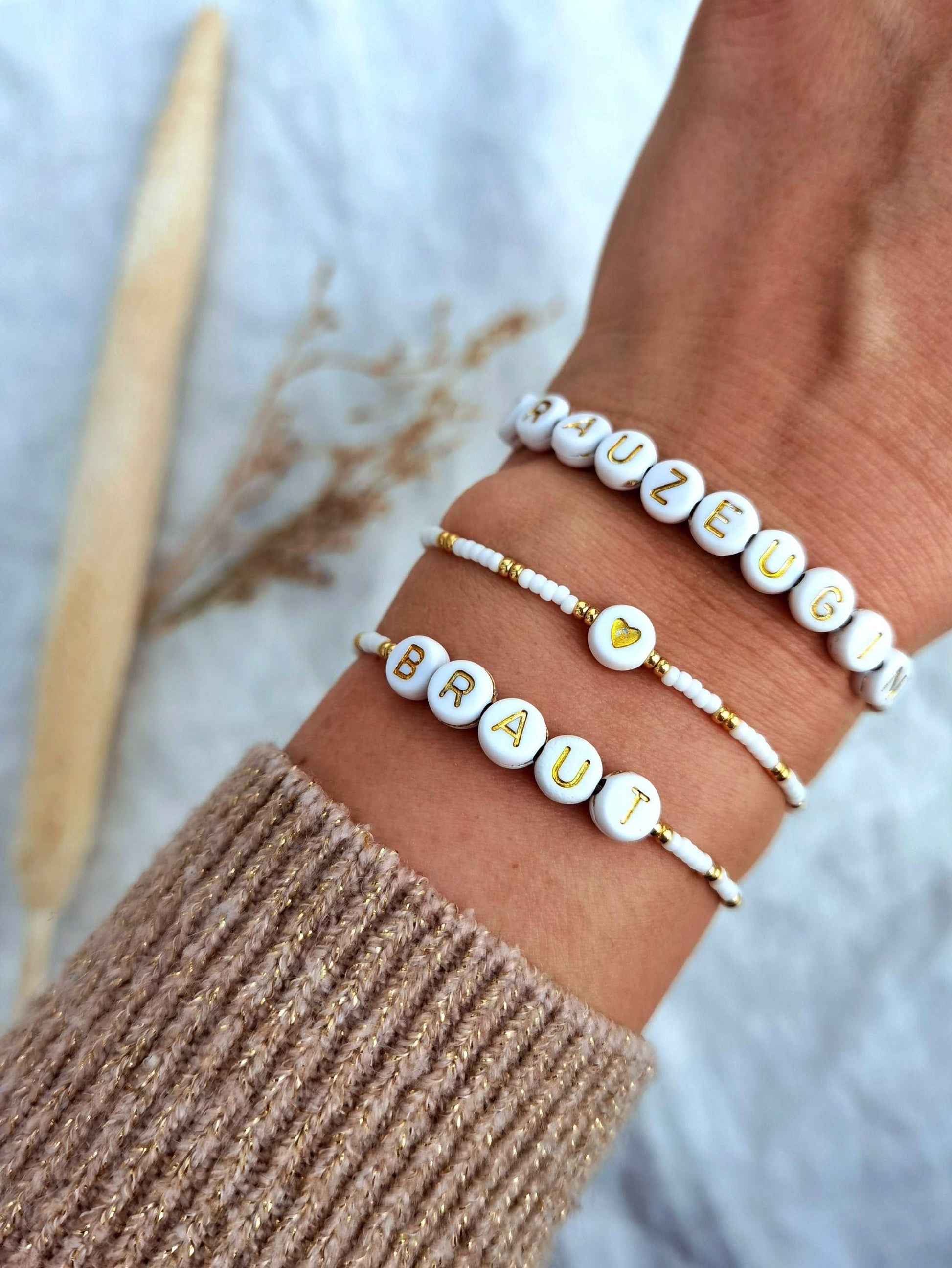 Tragefoto drei personalisierte JGA Armbänder in gold und weiß