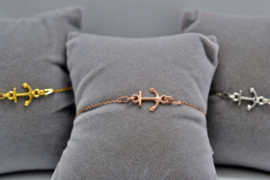 Anker Armkettchen in roségold, gold und silber jeweils auf einem grauen Schmuckkissen