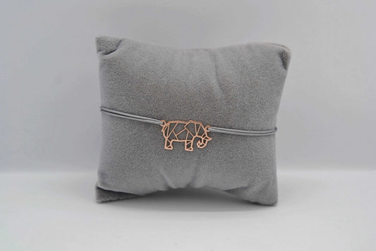Elefanten Armband in roségold mit grauem Band auf einem grauen Schmuckkissen