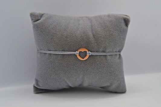 Roségoldenes Herzplättchen Armband auf grauem Schmuckkissen