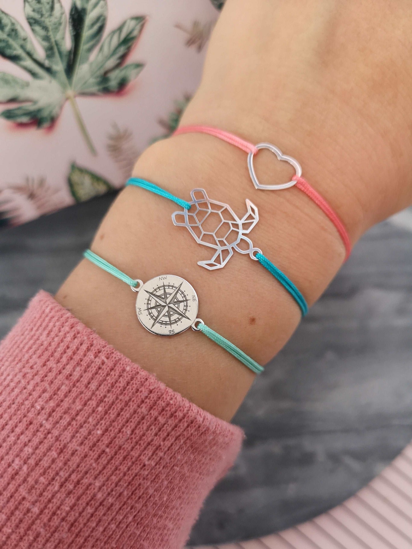 Tragefoto silbernes Kompass Armband mit mintgrünem Band, silbernes Schildkröten Armband mit türkisem Band und silbernes Herz Armband mit rosa Band