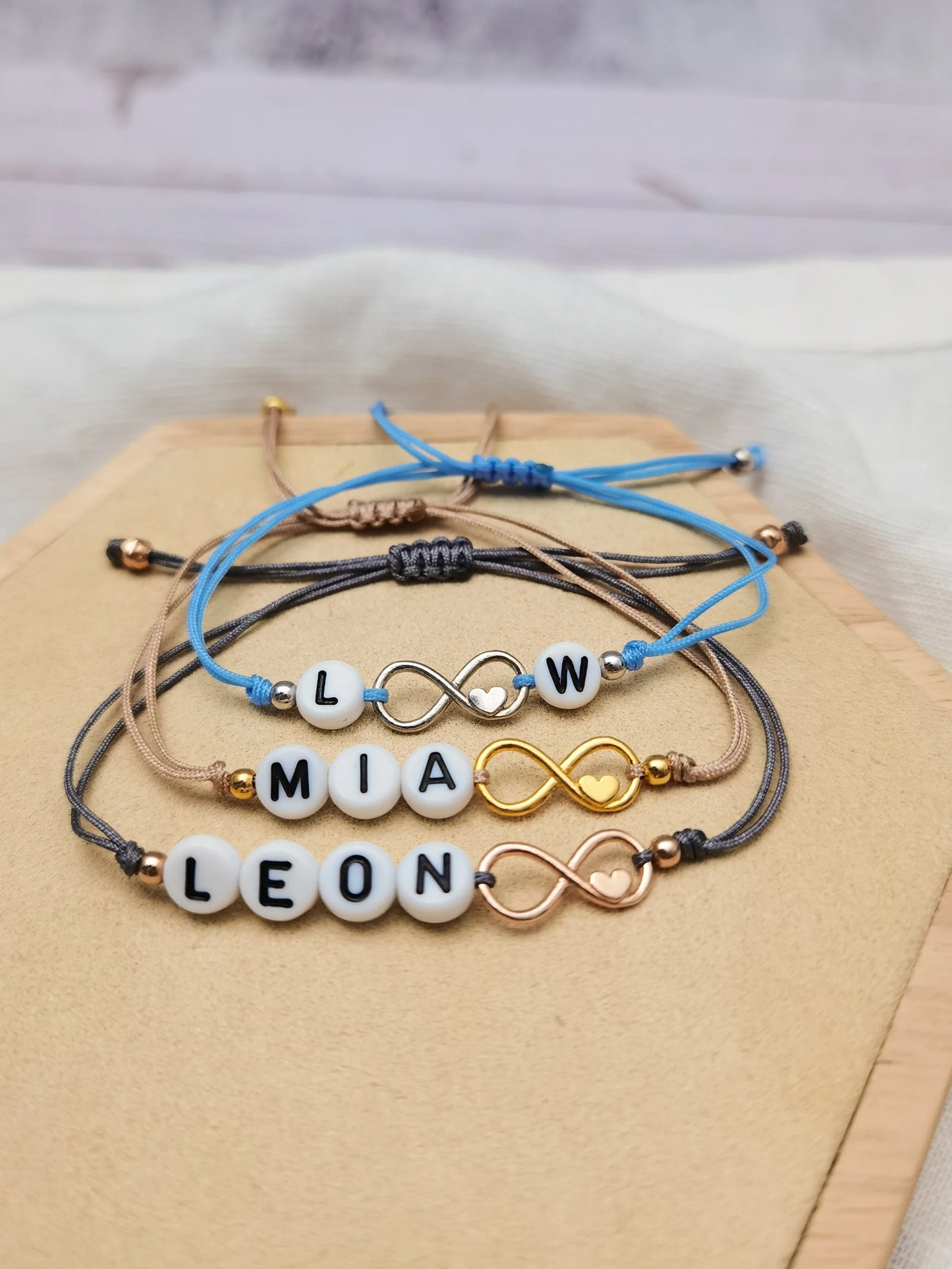 Drei personalisierte Armbänder mit Unendlichkeitszeichen in silber, gold und roségold
