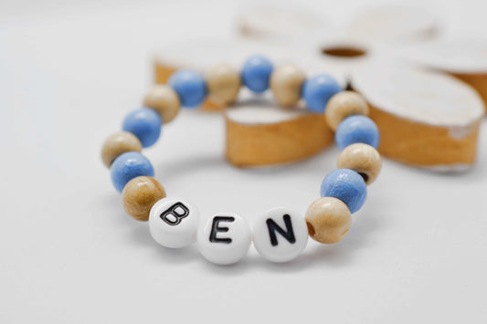 Personalisiertes Baby Armband mit Holzperlen in blau und natur und dem Namen Ben