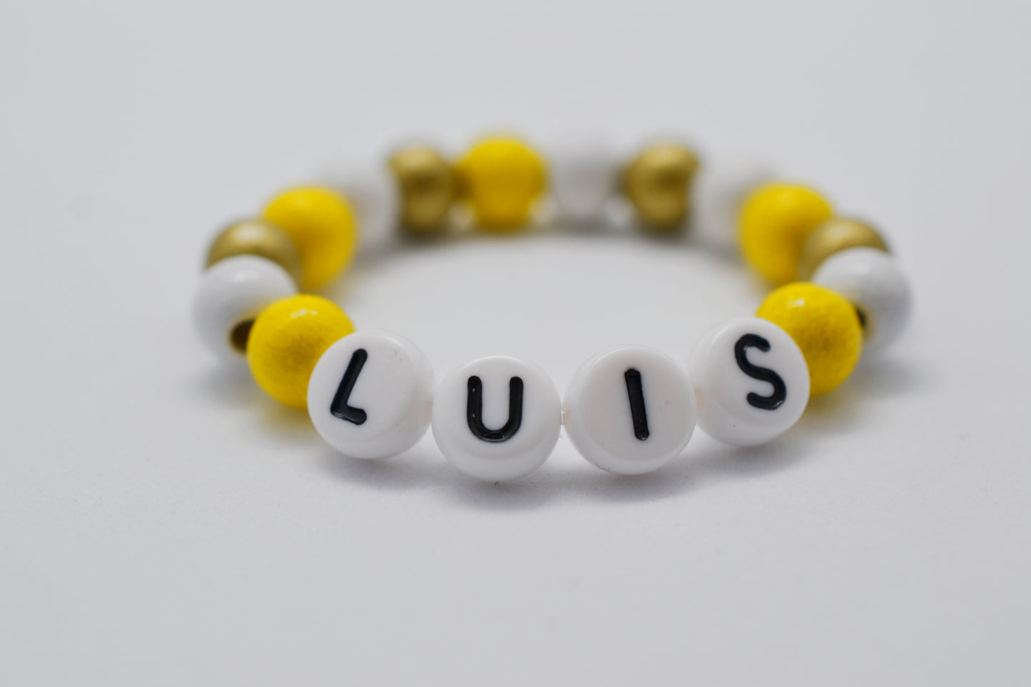 Baby Armband mit Namen "Luis" und Holzperlen in gelb, gold und weiß