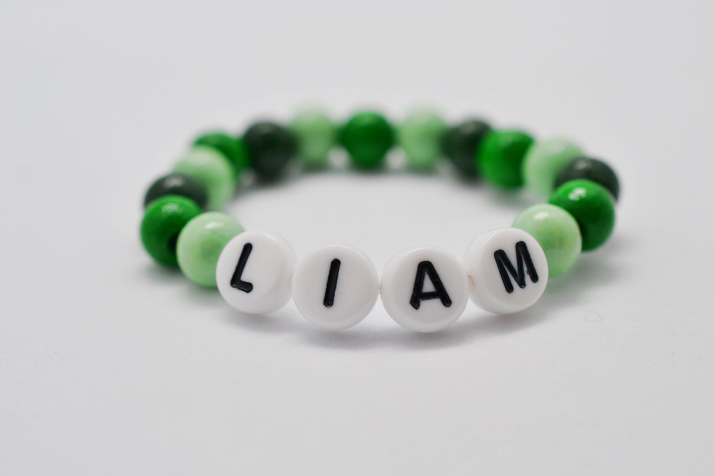 Geschenk zur Geburt Baby Armband mit grünen Holzperlen und Namen Liam