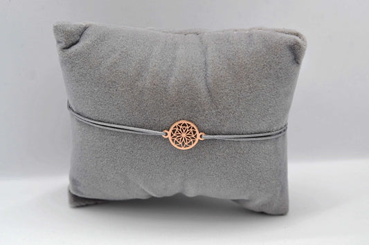 Roségoldenes Blumen Armband im Mandala Stil mit grauem Band auf einem grauen Schmuckkissen fotografiert