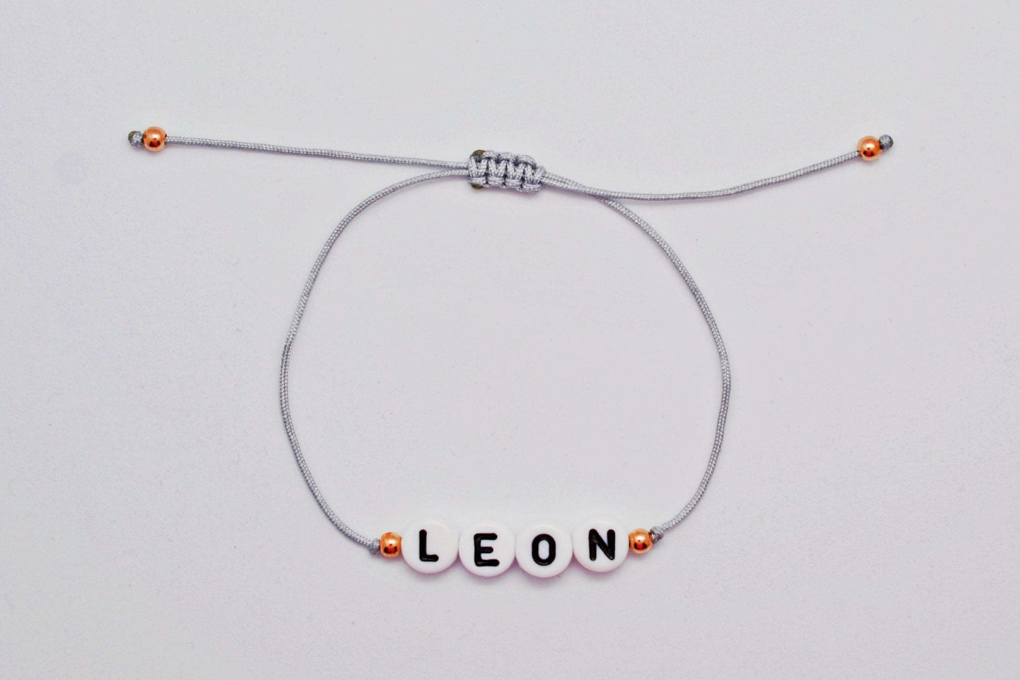 Personalisiertes Namensarmband mit Namen "Leon" mit grauem Band und roségoldenen Perlen