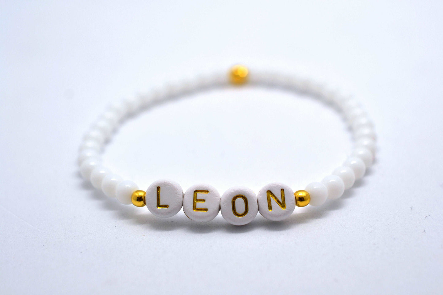 Personalisiertes Armband in weiß und gold mit dem Namen "Leon"
