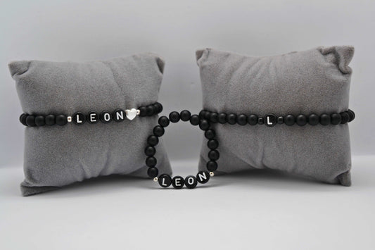 Drei personalisierte Familienarmbänder mit matt schwarzen Perlen - Perfekt als Geschenk zur Geburt