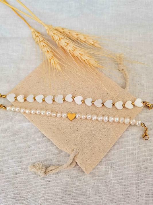 Festliche Armbänder mit Herzen und Süßwasserperlen in zwei Styles auf einem Leinensäckchen fotografiert