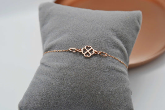 Roségoldenes Kleeblatt Armband auf einem grauen Schmuckkissen