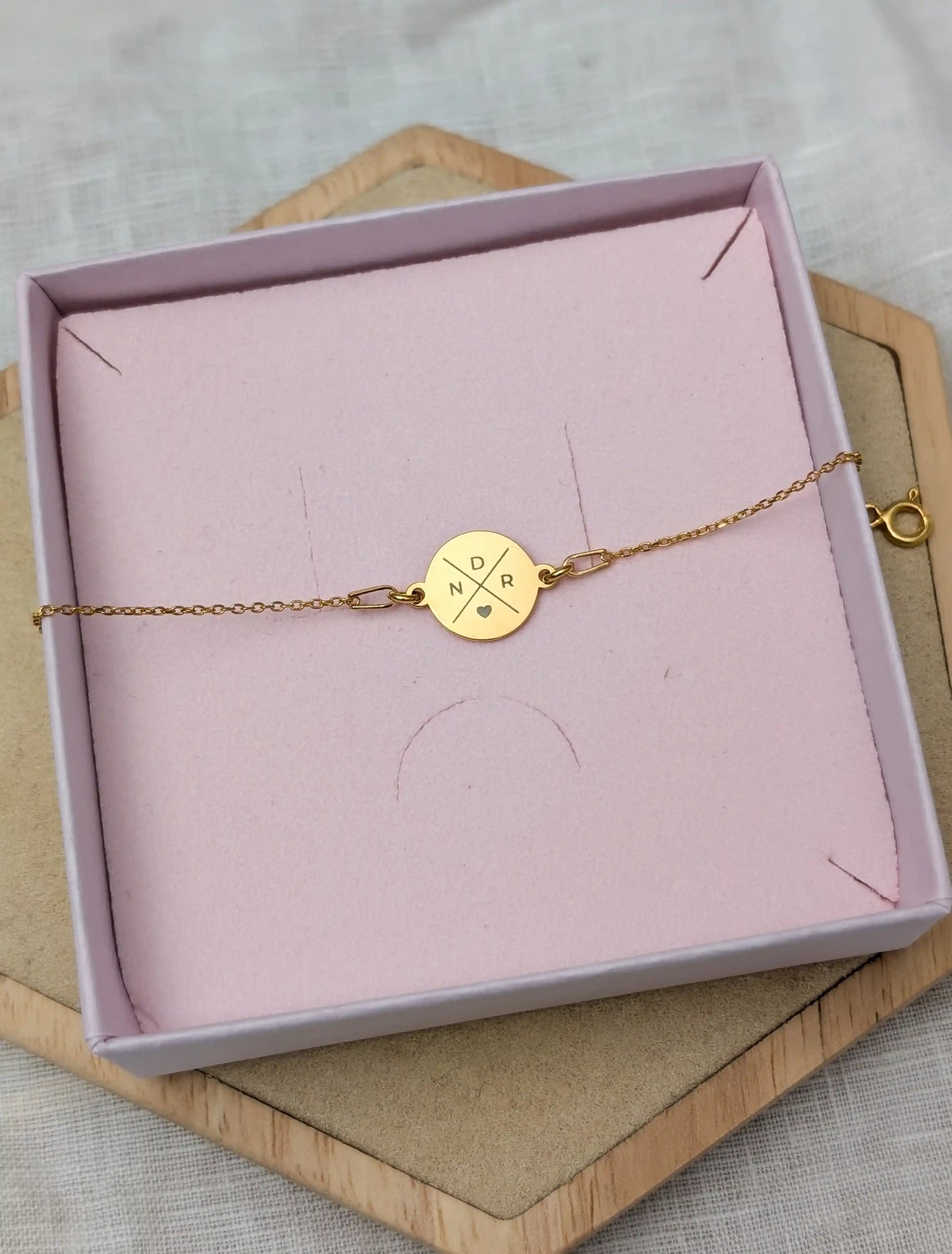 Goldenes Gliederarmband mit Wunschgravur fotografiert in einer rosa Schmuckbox