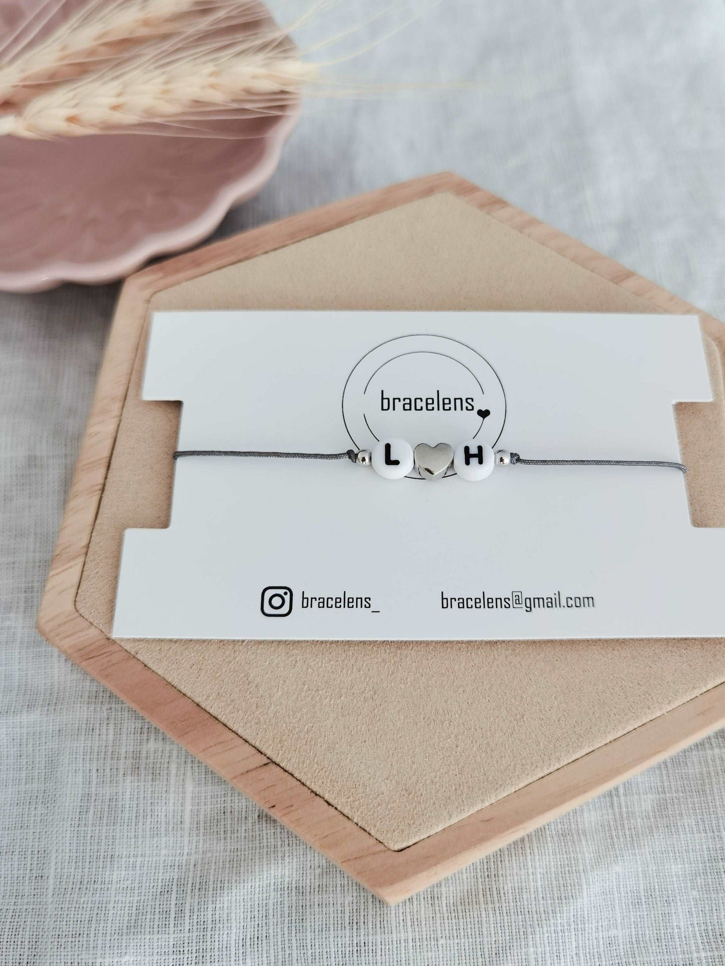 Personalisiertes Buchstaben Armband mit den Buchstaben L und H, einem grauen Band und einem Herz aus 925 Sterling Silber