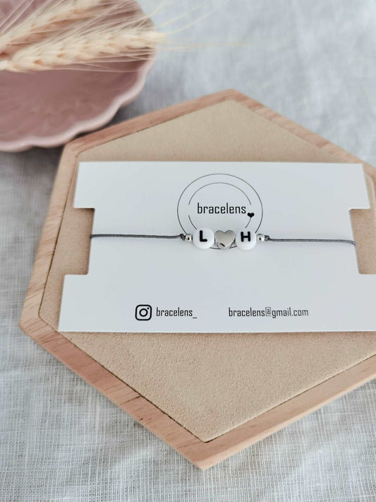 Personalisiertes Buchstaben Armband mit den Buchstaben L und H, einem grauen Band und einem Herz aus 925 Sterling Silber
