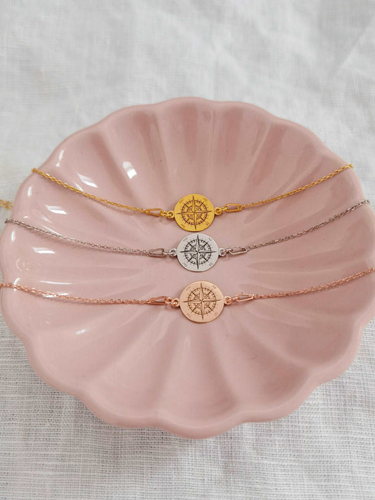 Drei Kompass Armbänder roségold, silber und gold in rosa Schmuckschale