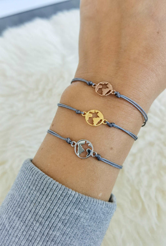 Tragefoto drei Weltkugel Armbänder in silber, gold und roségold mit grauem Band