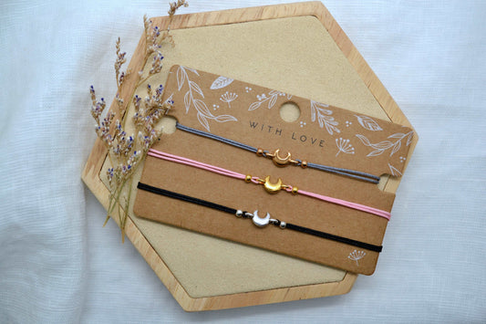 Drei Mond Armbänder in verschiedenen Farben auf einer Schmuckkarte