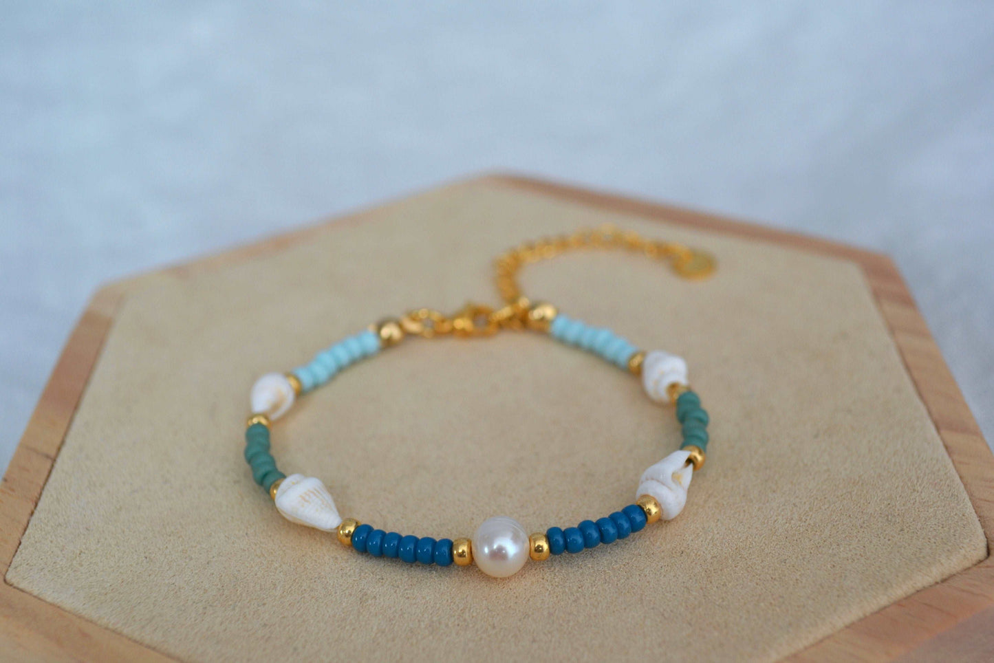 Armband mit vier Muscheln, blauen, grünen und goldenen Glasperlen und einer runden Süßwasserperle