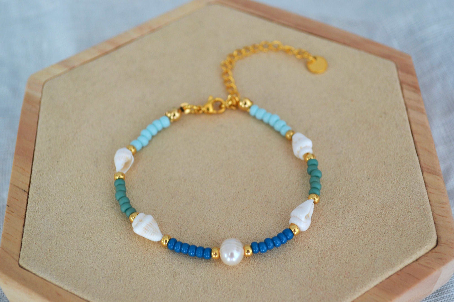 Nahaufnahme Armkette mit vier Muscheln, Glasperlen in blau, grün und gold sowie einer runden Süßwasserperle