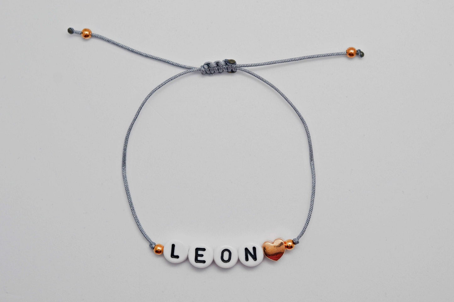 Personalisiertes Buchstaben Armband mit dem Namen Leon und einer Herzperle in roségold - Geschenkidee für Mamas