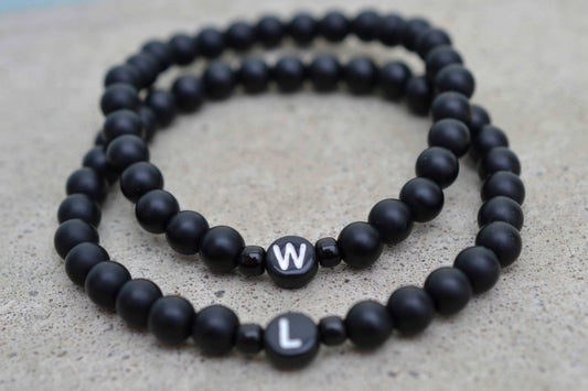 Zwei schwarze Perlenarmbänder mit je einem Buchstaben - Unisex Armbänder