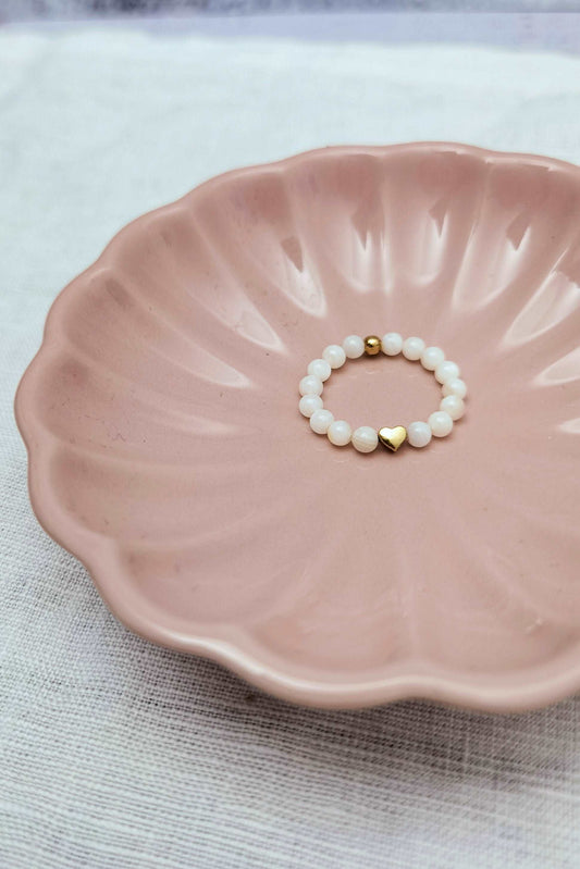 Perlenring weiß mit roségoldenem Herz in einer rosa Schmuckschale