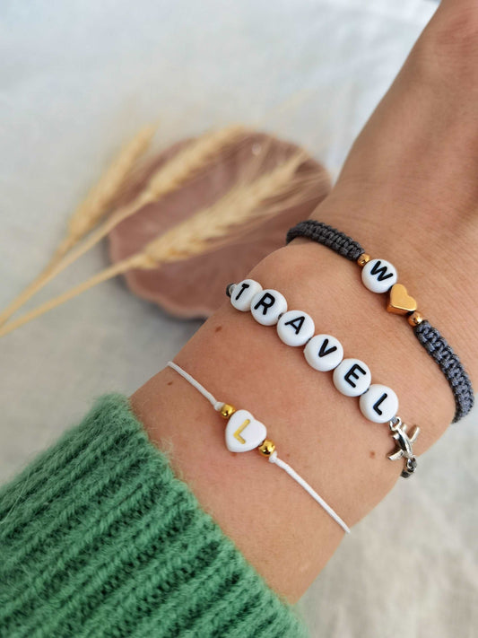 Tragefoto drei personalisierbare Buchstabenarmbänder in verschiedenen Stilen.