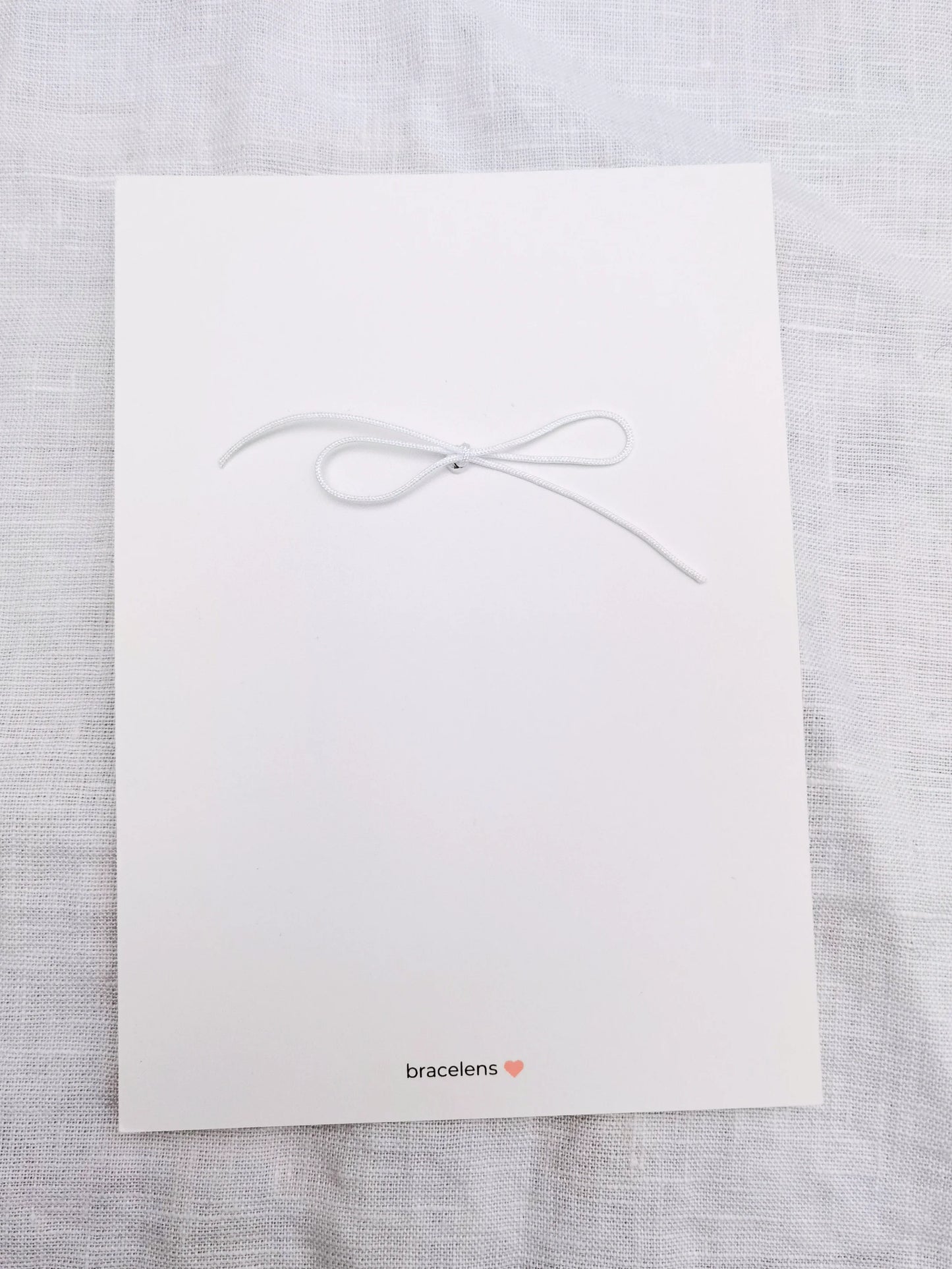 Rückseite Postkarte weiß mit einer Schleife