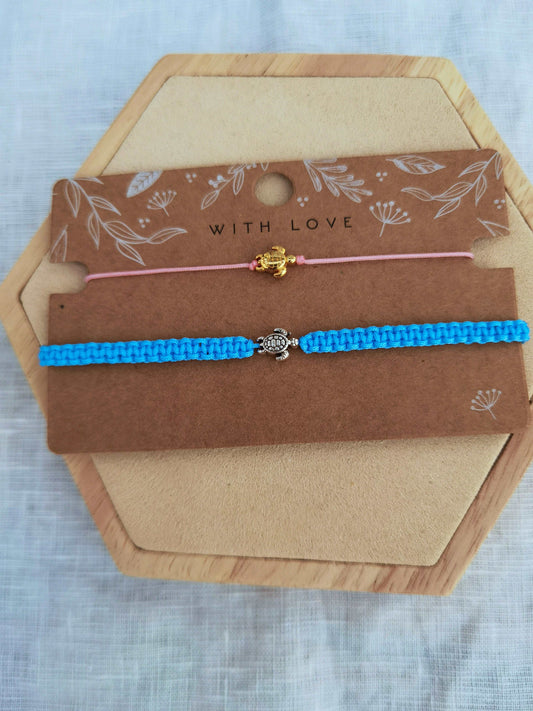 Schmuckkarte mit zwei Schildkrötenarmbändern in verschiedenen Farben auf einem Holz Sechseck