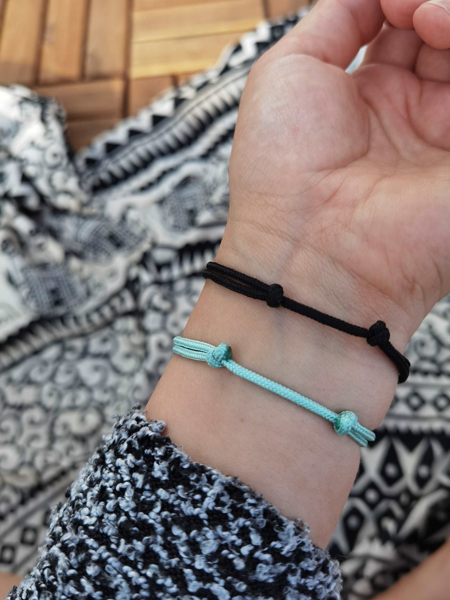 Tragefoto zwei Segeltau Armbänder Darstellung der "Unterseite" mit den Schiebeknoten. Ein Armband mint und eins schwarz