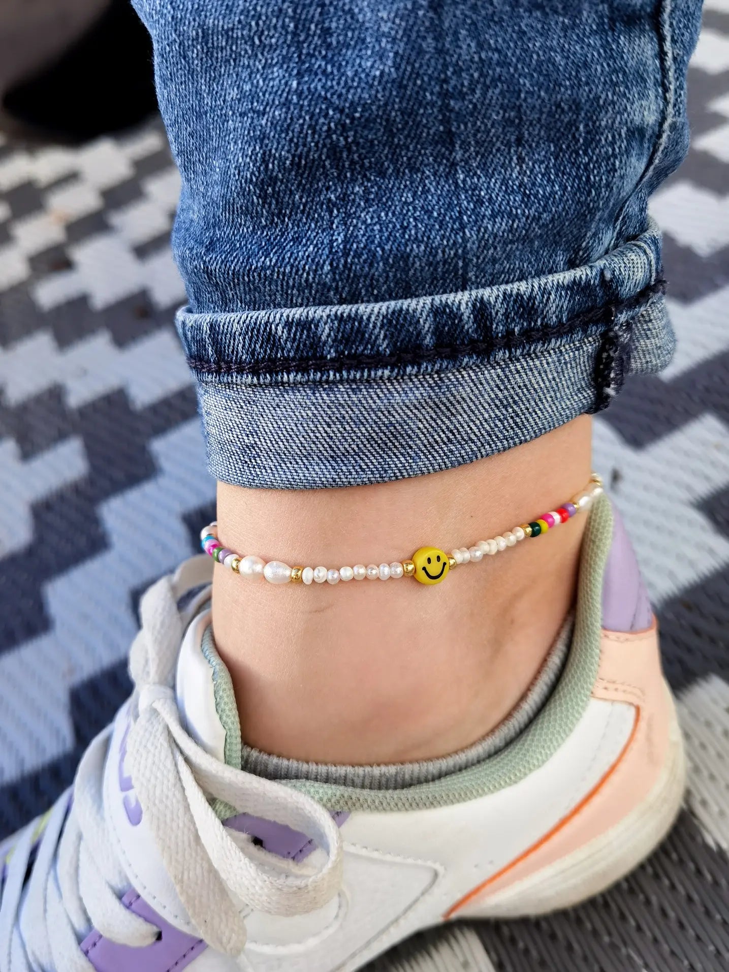 Nahaufnahme Tragefoto Fußkette mit gelbem Smiley, kleinen Süßwasserperlen und kleinen bunten Perlen