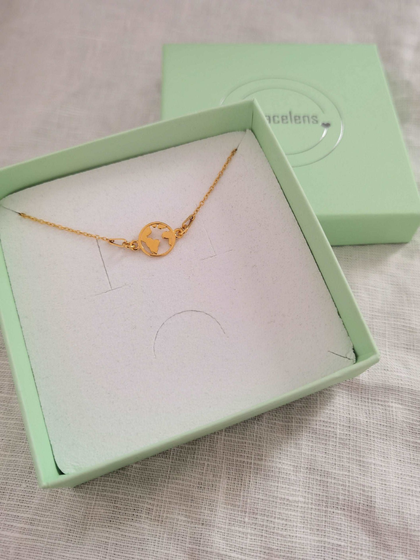 Goldenes Weltkarte Armband in mintgrüner Schmuckschachtel