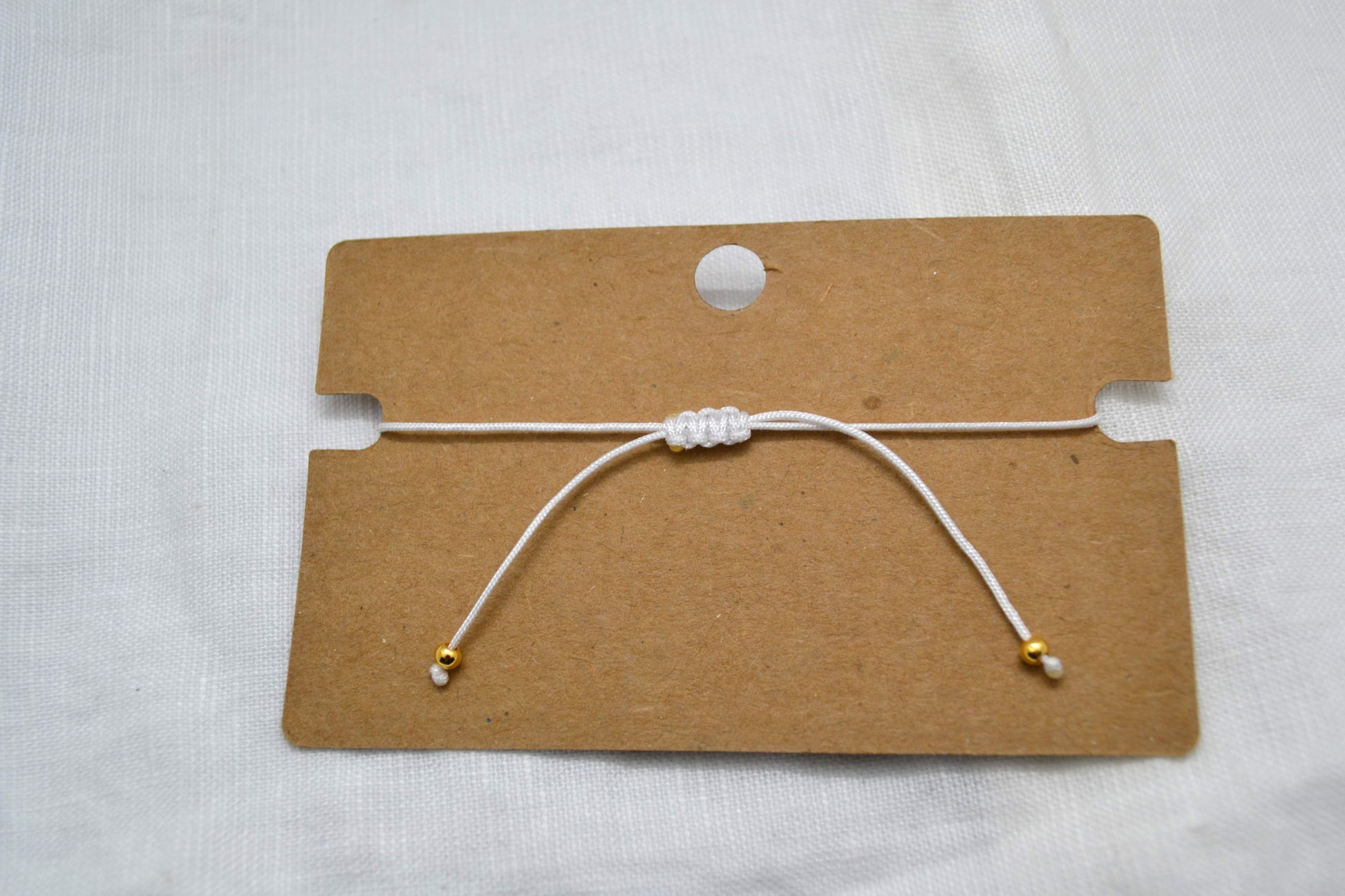 Makramee Verschluss weißes Armband mit zwei goldenen Perlen