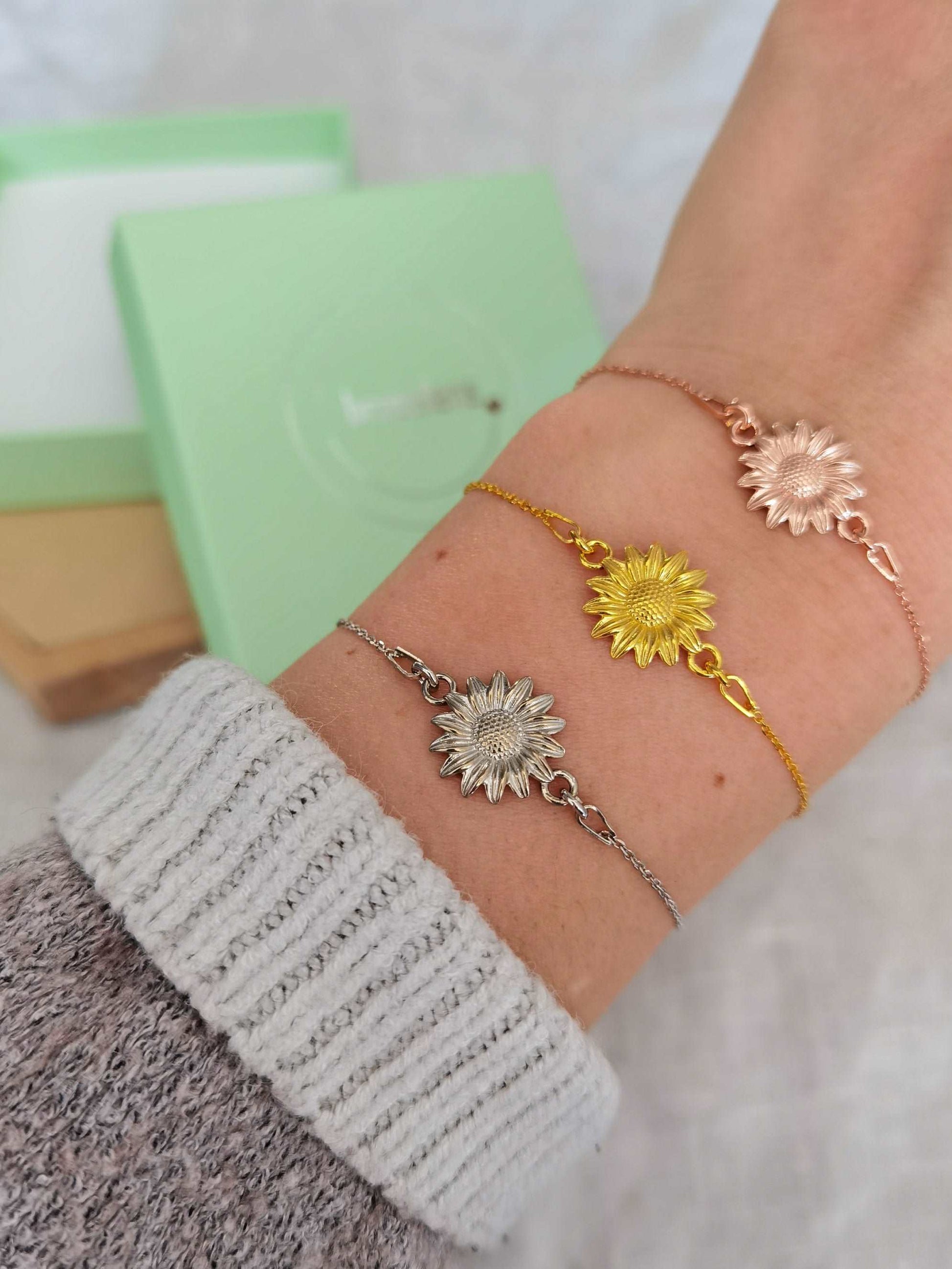 Tragefoto Sonnenblumen Armband in silber, gold und roségold vor einer mintgrünen Schmuckschachtel