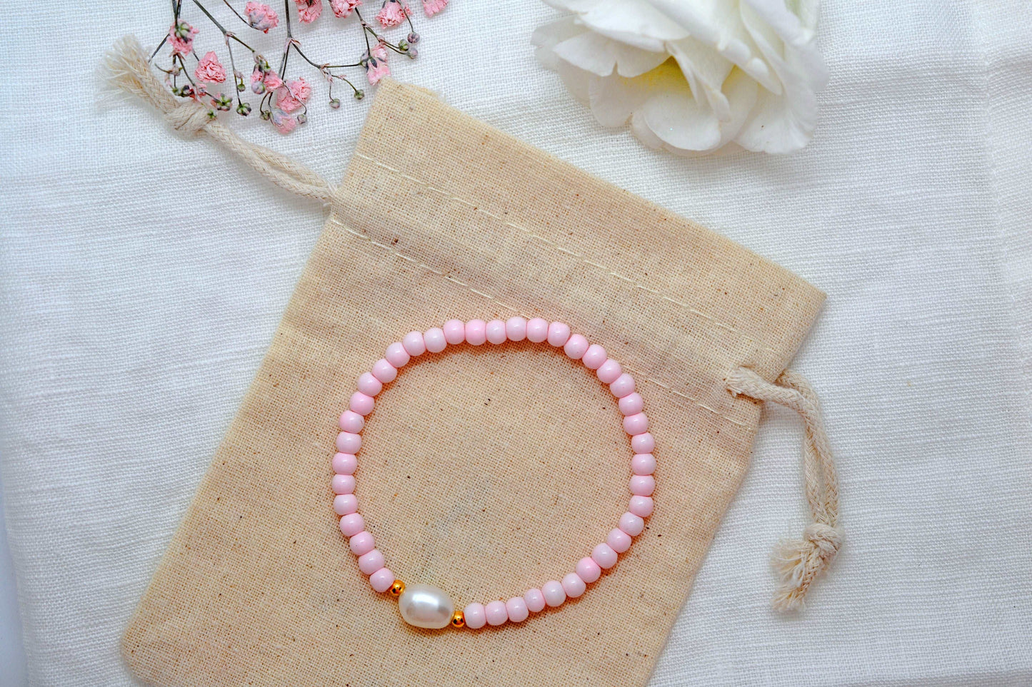 Armband mit rosa Glasperlen, einer großen Süßwasserperle und kleinen goldenen Perlen