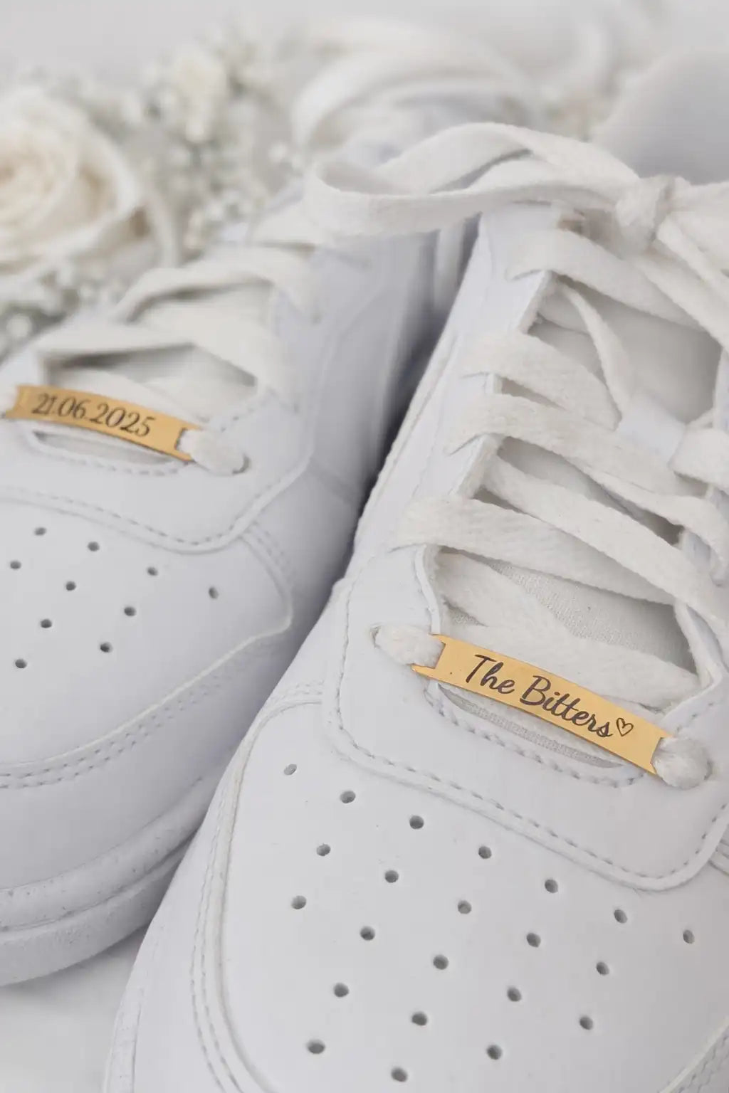 Detailaufnahme von Hochzeitssneakern mit gravierten Shoe Tags – elegantes Hochzeitsaccessoire aus Edelstahl