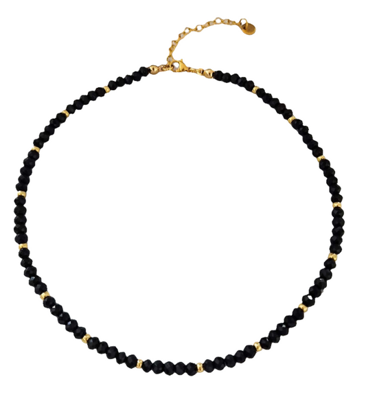 Schwarzer Perlen Choker mit goldenen Akzenten vor weißem Hintergrund