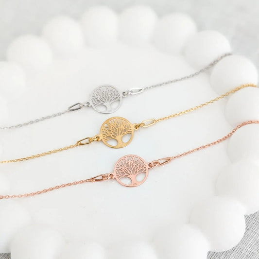 Drei Lebensbaum Armbänder in roségold, gold und silber auf einem weißen Untersetzer - Geschenkidee als Armband zur Konfirmation