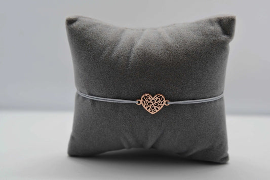Mandala Herz Armband roségold mit grauem Band auf einem grauen Schmuckkissen