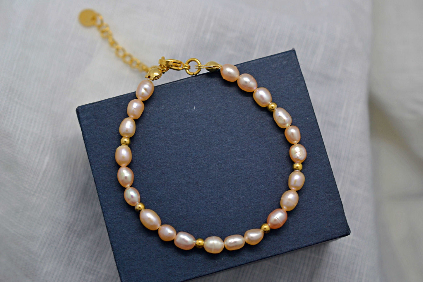 Rosafarbenes Süßwasserperlenarmband mit goldenen Perlen