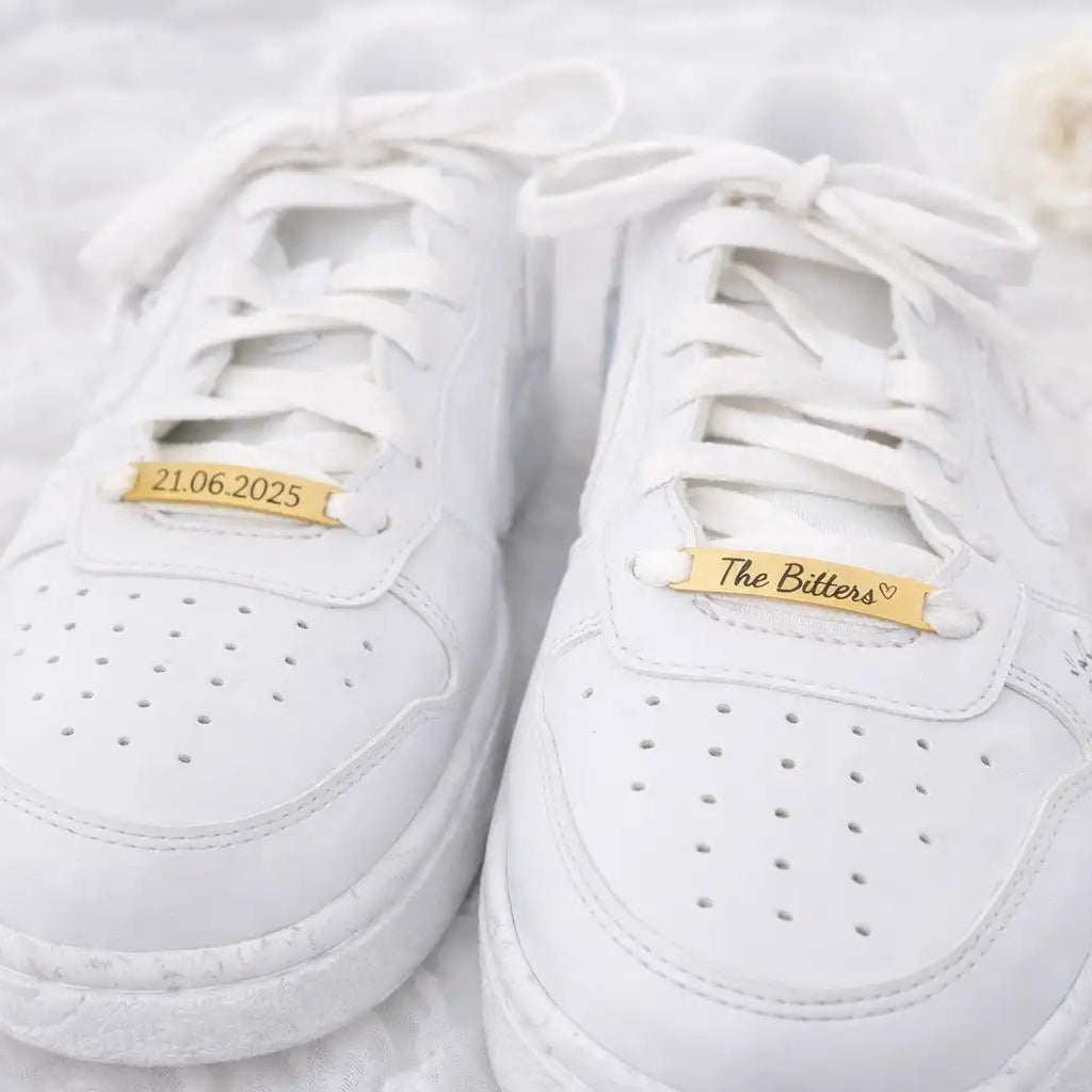 Personalisierte Shoe Tags aus Edelstahl an weißen Hochzeitssneakern – gravierte Schuh Tags für Braut und Bräutigam mit Namen und Datum