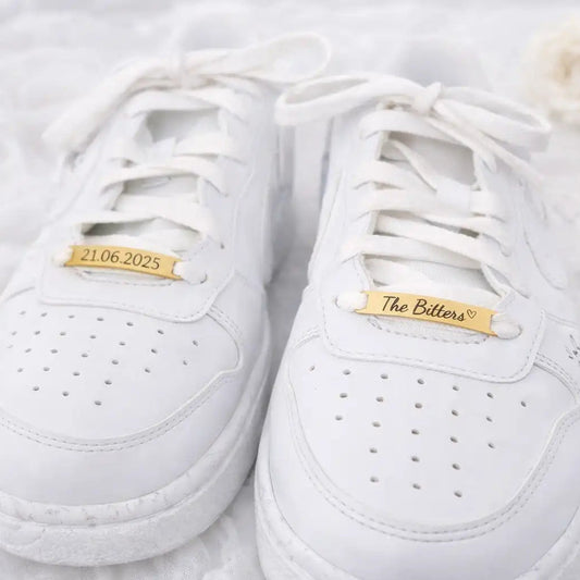 Personalisierte Shoe Tags aus Edelstahl an weißen Hochzeitssneakern – gravierte Schuh Tags für Braut und Bräutigam mit Namen und Datum