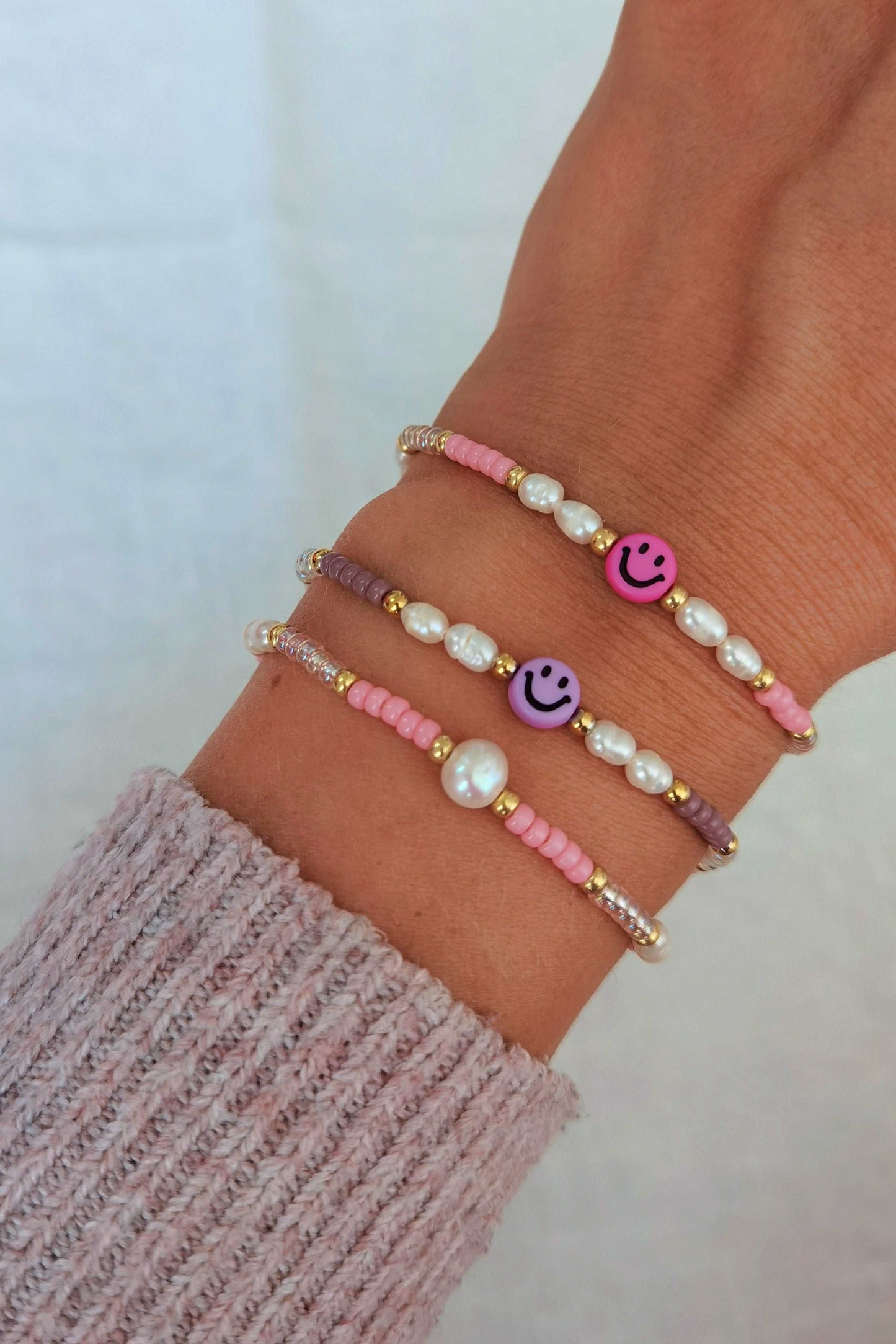Tragefoto zwei Smiley Armbänder und ein Süßwasserperlen Armband in rosa und lila