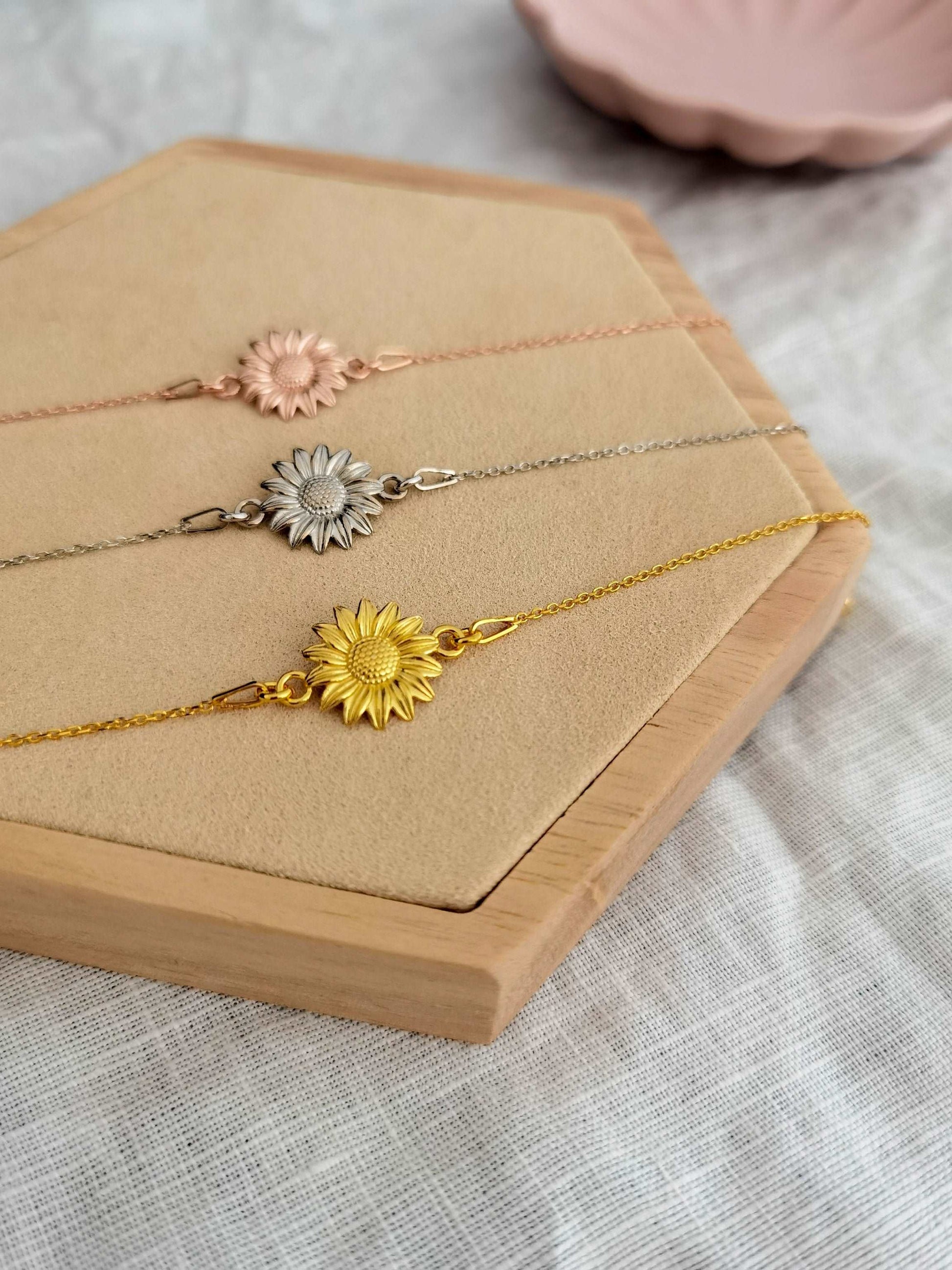 Sonnenblume Armband in gold, silber und roségold auf einem Holz Sechseck