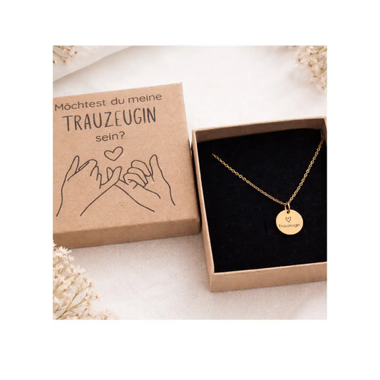 Goldene Trauzeugin Kette mit graviertem Anhänger in einer Geschenkbox aus Kraftkarton mit der Aufschrift „Möchtest du meine Trauzeugin sein?“. Perfektes Trauzeugin Geschenk zur Hochzeit.